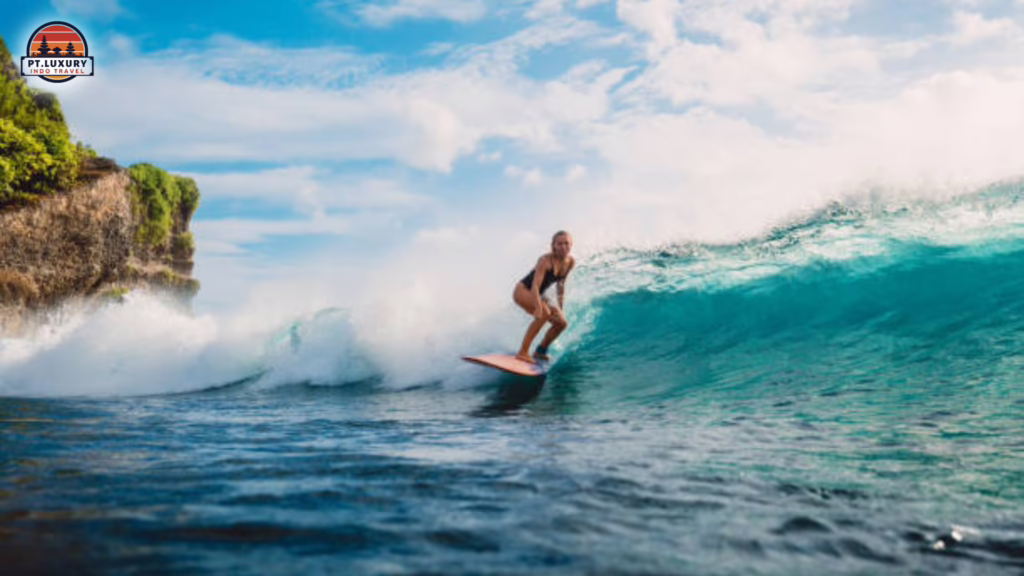 Traveler surfing on blue ocean waves in Bali during an exciting beach adventure experience.
