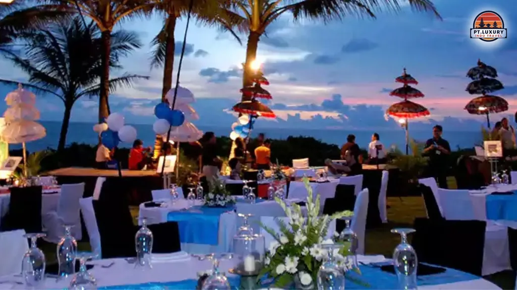 Corporate guests enjoying a luxury gala dinner on a Bali beach with elegant outdoor dining setup