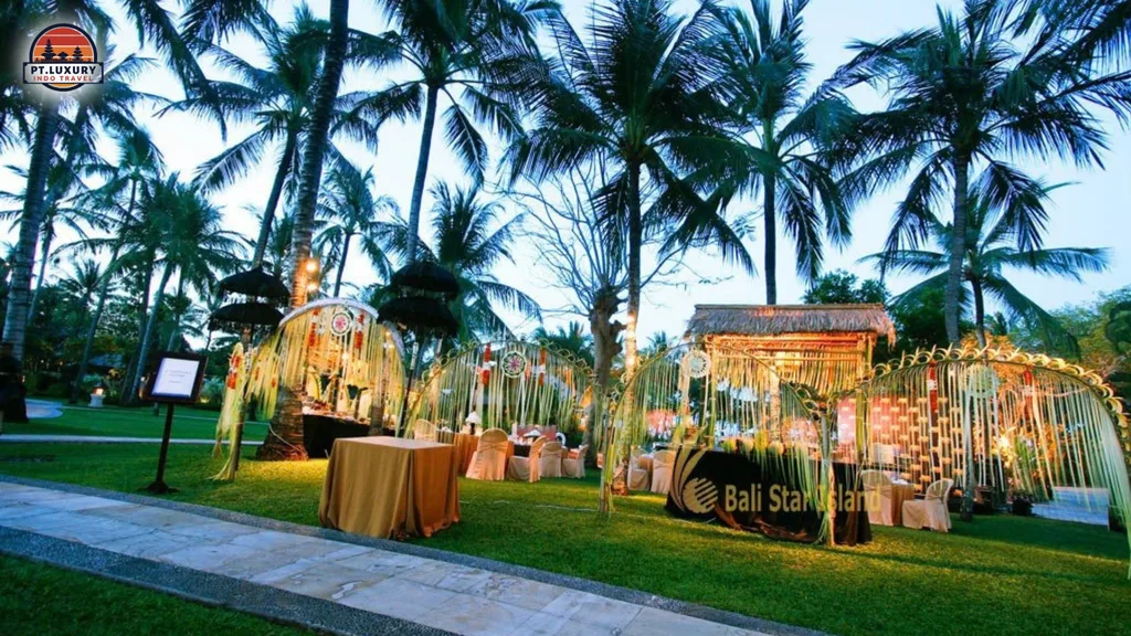Corporate group enjoying an elegant outdoor dinner surrounded by tropical greenery and palm trees in Bali